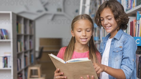 Kids reading from book with copy space