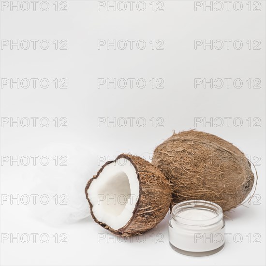 Close up moisturizing cream loofah coconut white backdrop