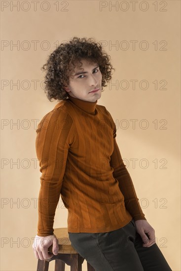 Curly man with brown blouse posing 2
