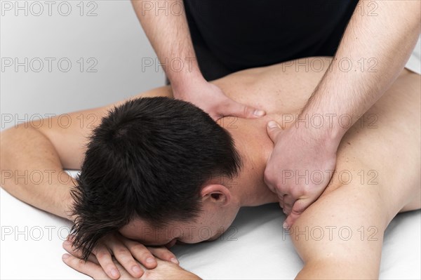 Male patient being given back massage by physiotherapist