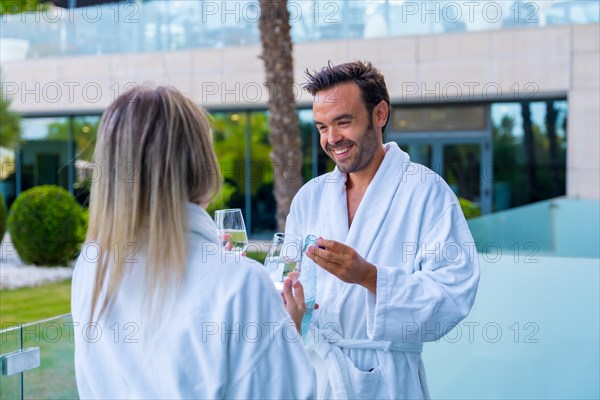 Happy couple drinking wine in the terrace of a luxury hotel room