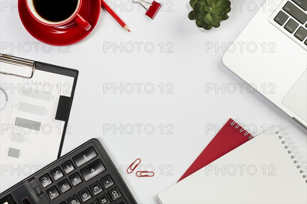 Calculator laptop spiral notepad coffee cup cactus plant white desk