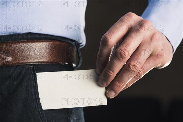 Crop man taking out business card