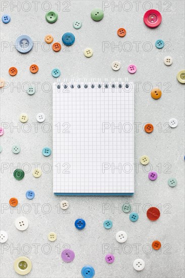 Empty notepad surrounded by colourful buttons