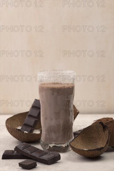 Front view chocolate milkshake glass with coconut copy space