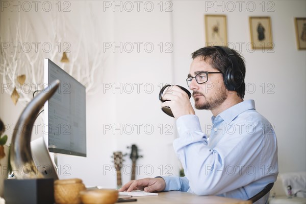 Man working computer drinking