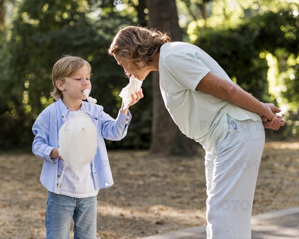 Medium shot grandma eating cotton candy