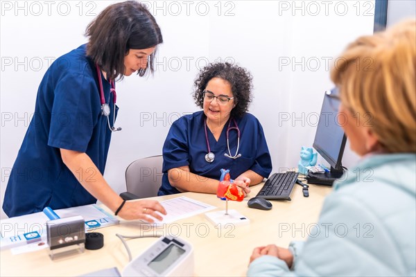 Nurse showing an analysis to the cardiologist doctor in the cardiology clinic together with a client