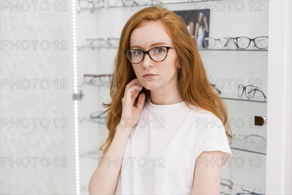 Portrait serious attractive woman looking camera optics store