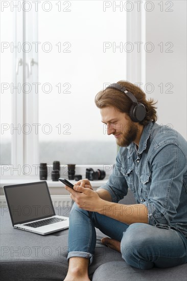 Man sitting couch with smartphone