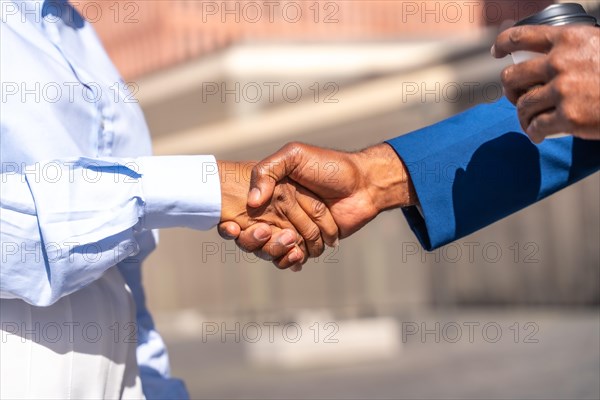 Close-up of a handshake of african business people outdoors on a sunny day