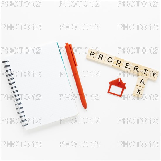 Top view spiral diary near wooden blocks with property tax text isolated white background
