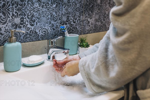 Crop woman washing hands