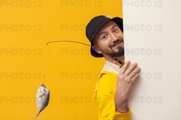 Fisherman holding fishing rod posing while smiling