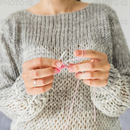 Close up female s hand crocheting with pink thread