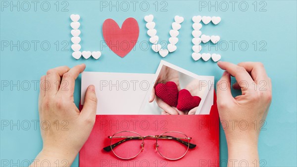 Crop hands opening envelope near love writing