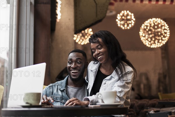 Happy couple looking laptop