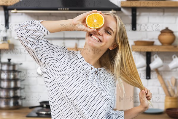 Medium shot smiley woman with half orange