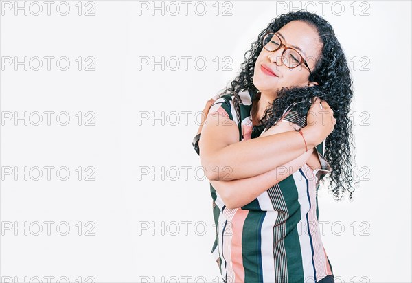 Afro woman hugging herself isolated. Smiling young woman hugging herself with self love. Self love concept