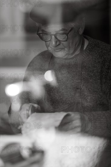 Senior expert luthier artisan violin maker carve sculpt chisel ribs of a new classical model cello in workshop Cremona Italy