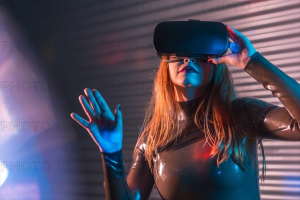 Woman submerged in metaverse reality by using VR goggles in an urban night space with neon lights