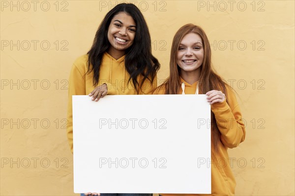 Best friends holding blank card