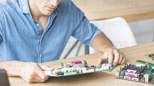 Close up hardware engineer repairing motherboard