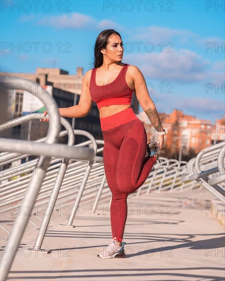 Frontal view of a fit woman stretching legs in an outdoors park