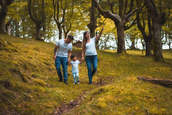 Boy learning during a walking in the forest with his parents