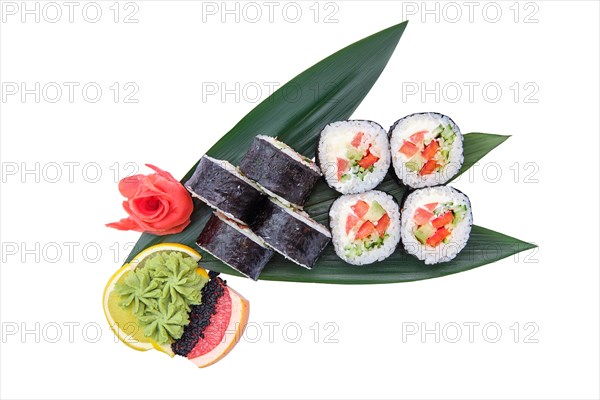 Overhead view of sushi roll with trout with avocado and cucumber served on bamboo leaves