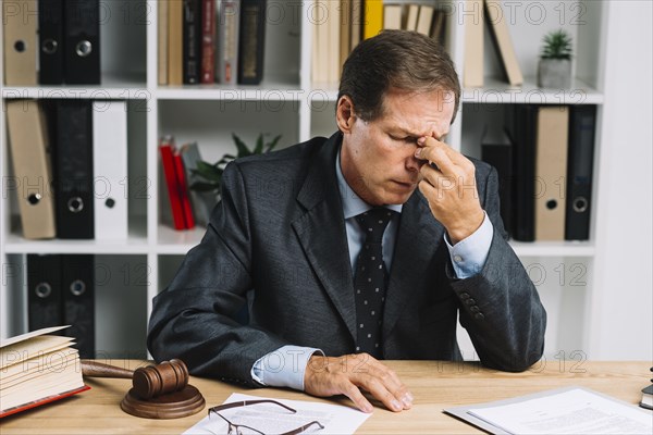 Tired mature lawyer sitting courtroom