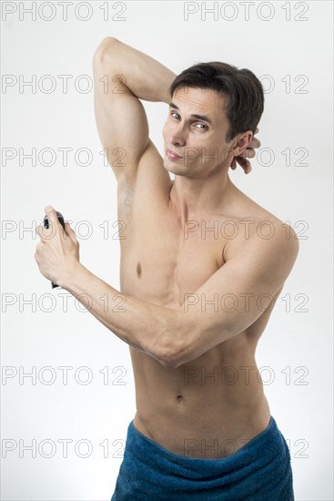 Front view man spraying deodorant