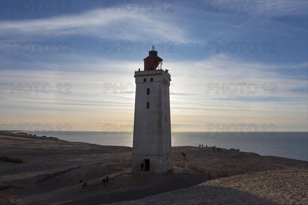 Lighthouse and dune at sunset