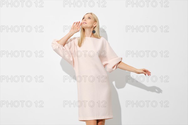 Cute blonde woman in short sheath dress looks up