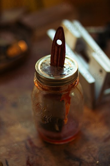 A jar containing water painting made with natural ingredients to paint instruments in luthier workshop