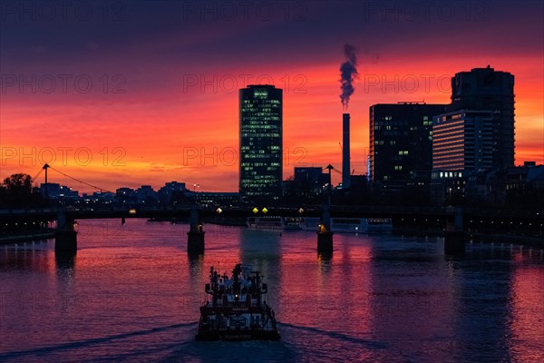 A ship sails along the Main towards Frankfurt's Westhafen harbour in the evening. The office lights are lit up in the Westhafen Tower