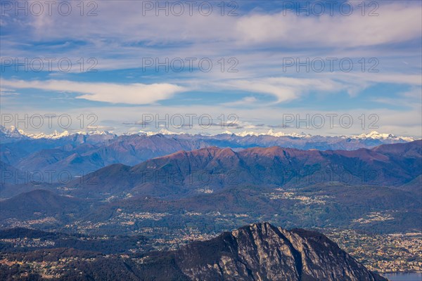 Aerial View over a Beautiful Mountainscape and And Snow Capped Mountain and with Floating Clouds in a Sunny Day in Lugano
