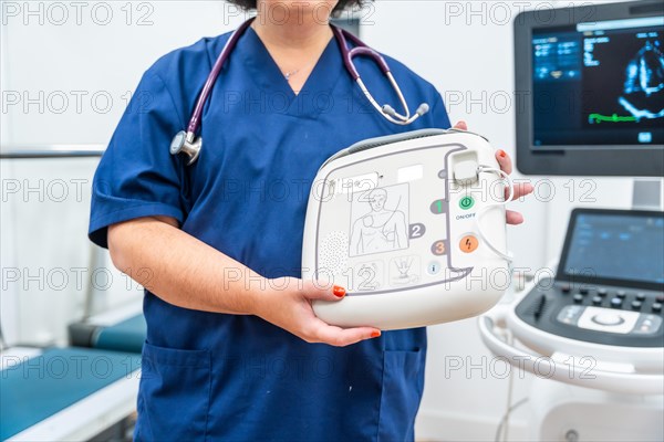 Close-up of an unrecognizable cardiologist explaining how a small defibrillator works