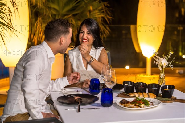 Couple enjoying a romantic and luxury dinner outdoors in a restaurant terrace