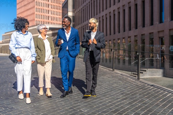 Group of multi-ethnic business people walking relaxed on a coffee break outdoors