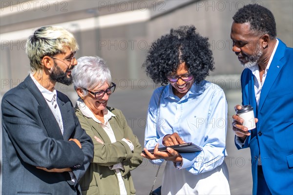 Selective focus on a group of multi-ethnic business people using digital tablet in an outdoors meeting