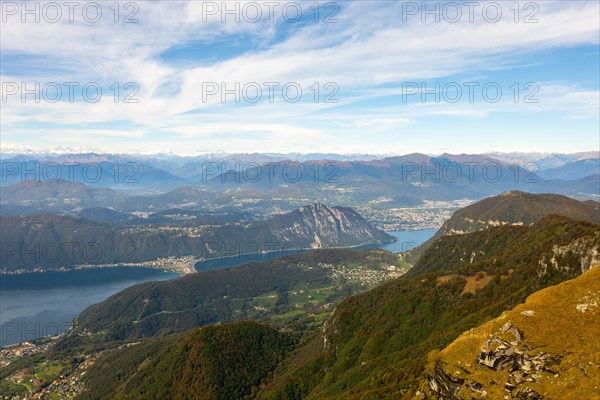 Aerial View over Beautiful Mountainscape with Snow Capped Mountain and Lake Lugano and City of Lugano in a Sunny Day From Monte Generoso