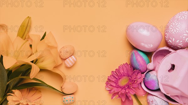 Fresh lily gerbera flowers with easter eggs yellow backdrop