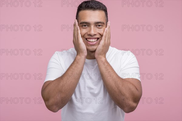 Front view smiley handsome man posing with palms his face