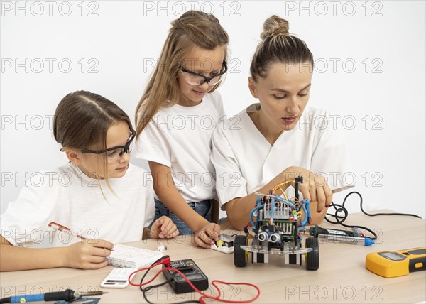 Girls female teacher doing science experiments together