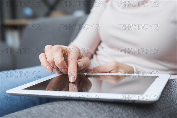 Close up woman s hand touching modern digital screen with finger