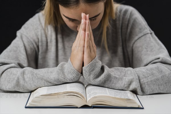 Front view woman with bible praying