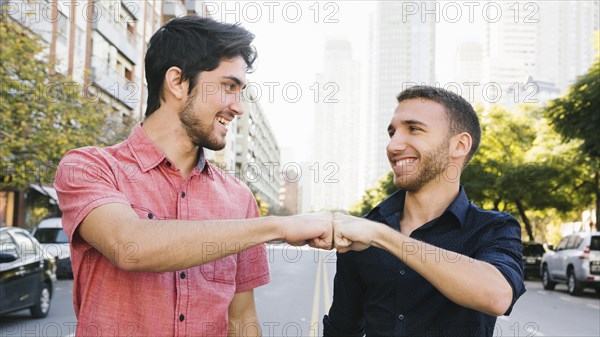 Happy gay couple greeting street