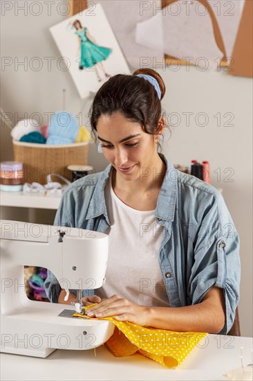 Medium shot woman sewing with machine