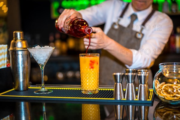 Bartender preparing a Sex on the beach cocktail in a luxury bar